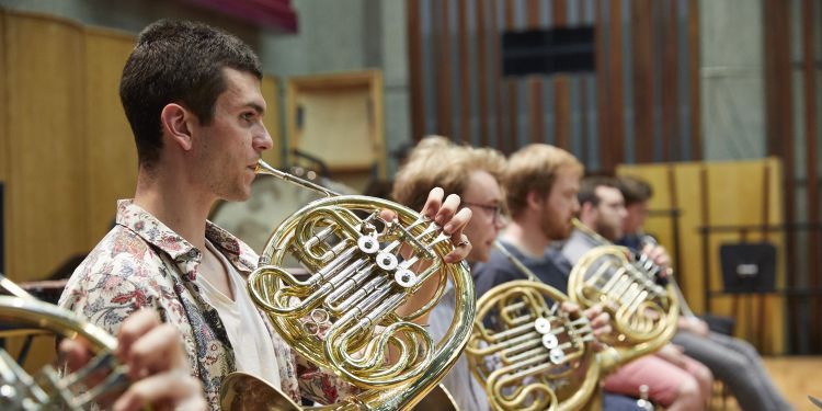 Horn players in an orchestral rehearsal