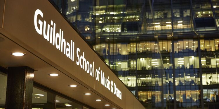 Milton Court box office exterior on Silk Street, closeup of sign saying "Guildhall School of Music & Drama"