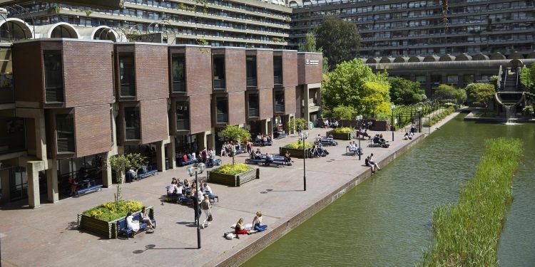 Lakeside terrace shot from above on a sunny day with students eating lunch and socialising outside