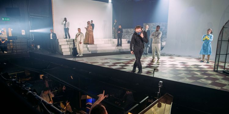 Stage Manager on stage speaking to conductor during a technical rehearsal