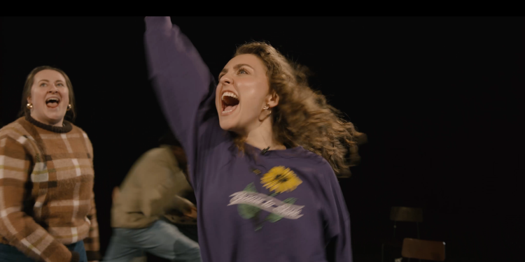 actor in purple jumper cheering