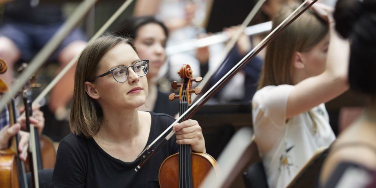 Violin section resting during a rehearsal