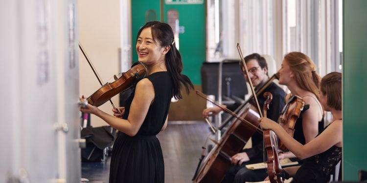String chamber players laughing while waiting to go on stage