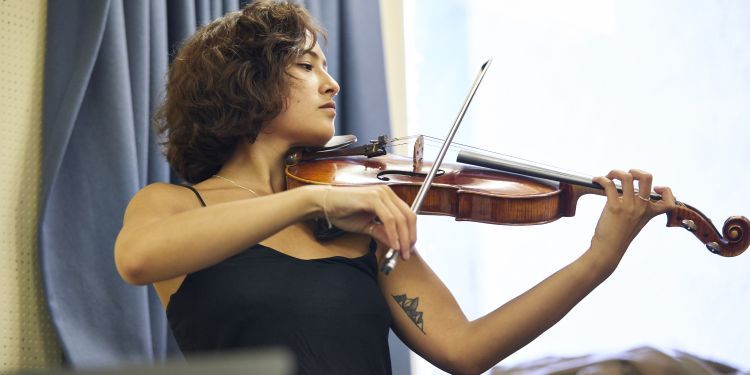 Violinist in a practice room, preparing for a performance