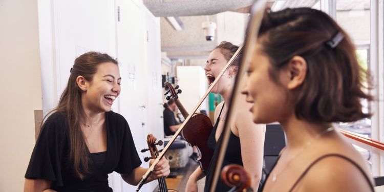 String chamber players laughing while waiting to go on stage