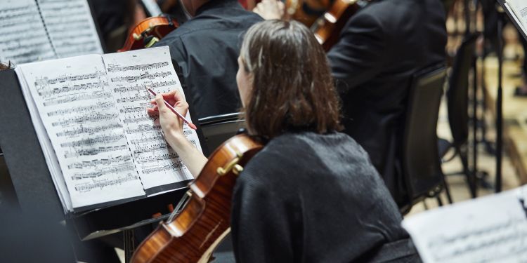 Cellist making notes on their sheet music