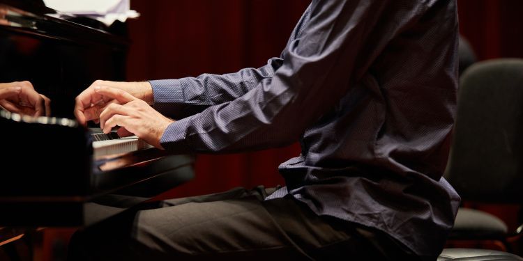 Hands playing a piano