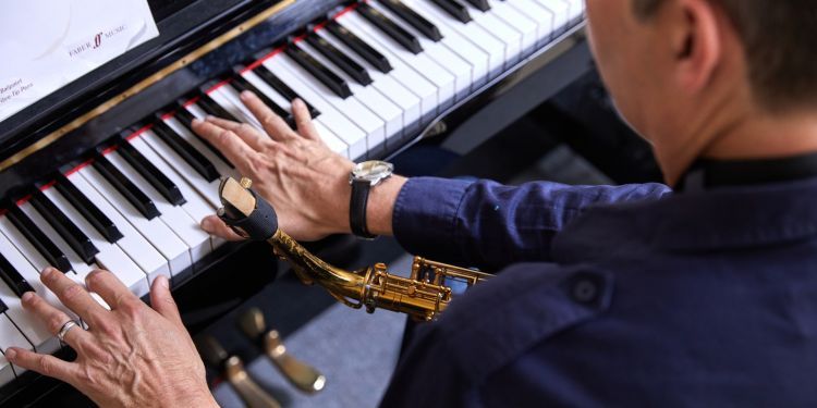 A close up of a mans hands playing the piano