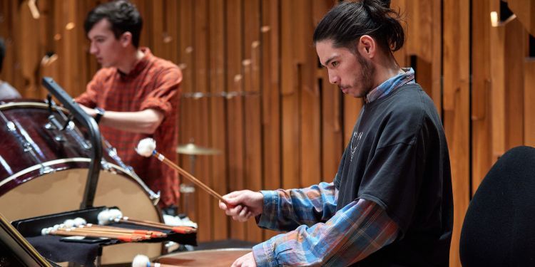 Timpani player hitting the drums in a GSO rehearsal