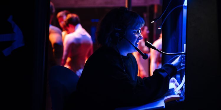 Deputy Stage Manager working at a cueing desk at the side of the stage