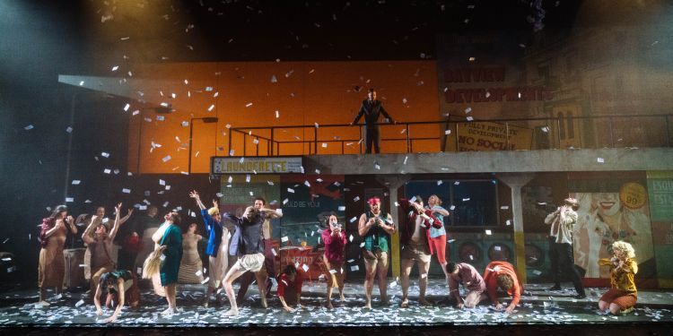 Prop paper money raining down on the stage as the chorus and singers snatch them out of the air