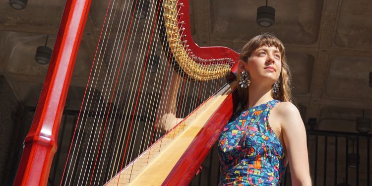 Harpist in a colourful dress with a red harp
