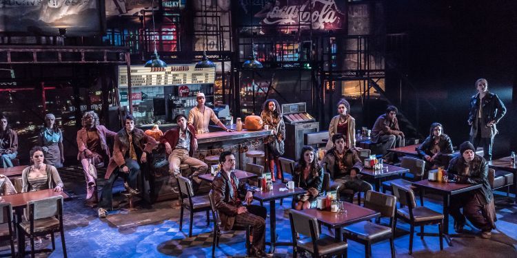 Actors on stage in a set like an old new york speakeasy