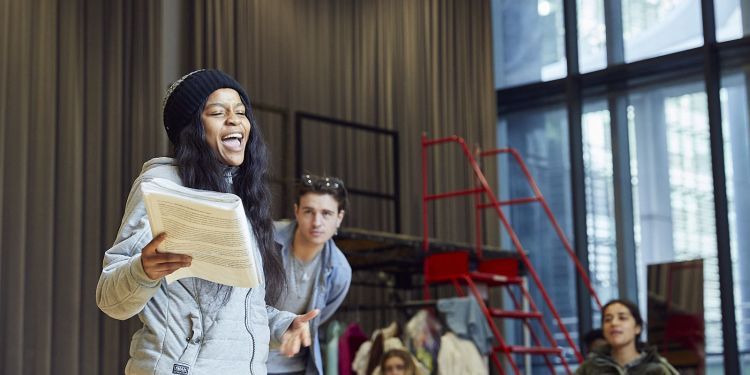 Actors read lines from scripts during a rehearsal