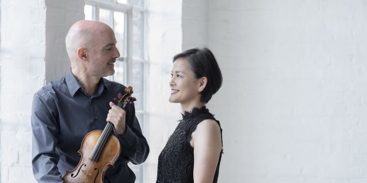 Male violinist and female musician looking at each other