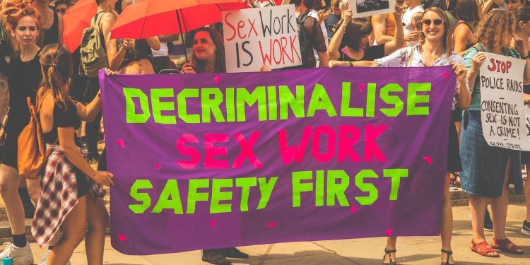 Several females at a protest holding up posters