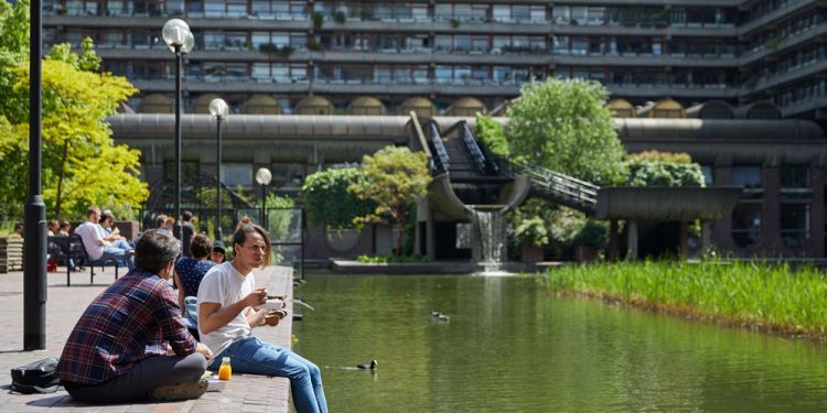 student sat by water next to campus