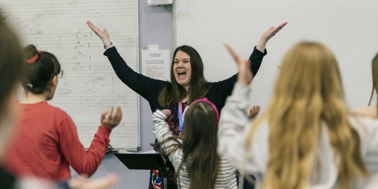 Tutor Laura and students with arms in the air