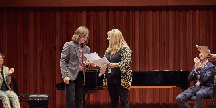 Rosie Whitfield (right) presents Daniel Hibbert with his certificate (left)