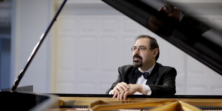 Pianist, Boris Berman sitting at a piano