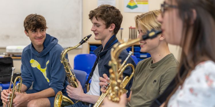 Three boys playing the saxophone