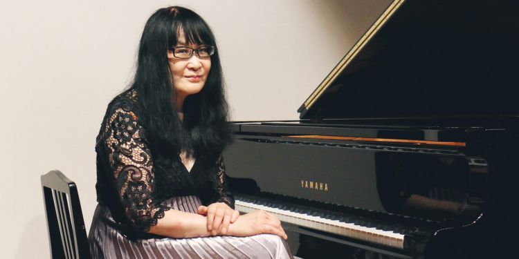 Kyoko Hashimoto sitting at a piano