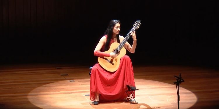 A woman playing guitar on a stage