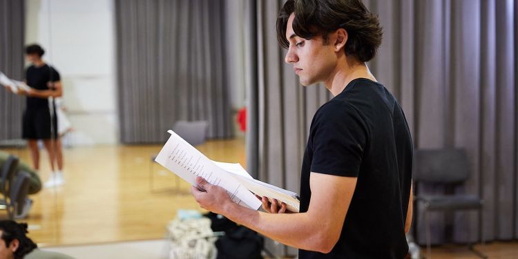 participant holding a text on acting course 