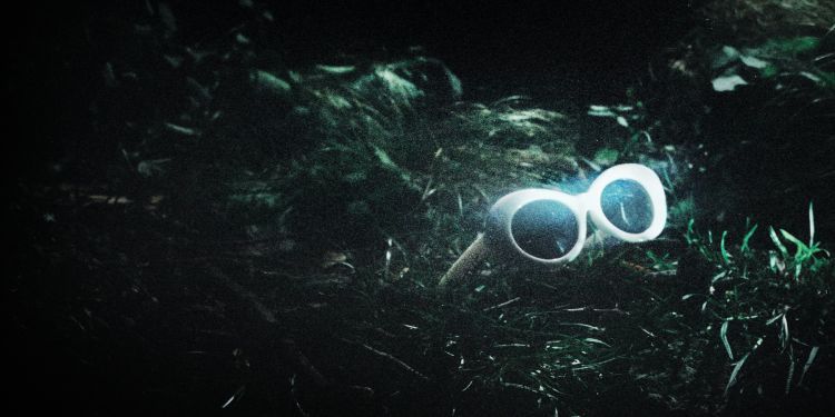 White sunglasses on grass at night