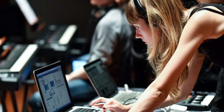 A woman wearing headphones performing live using Ableton