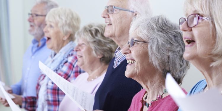 Photo of mature adults singing from sheet music 