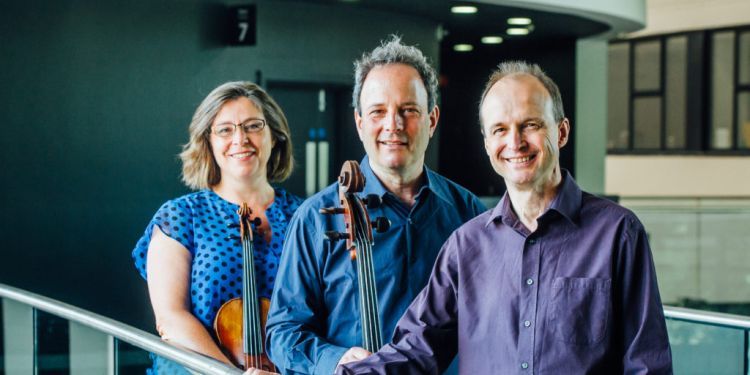 The Gould Trio smiling together with their instruments 