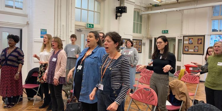 A group of teachers singing in a classroom