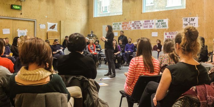 Woman talking to audience sat around her in a circle