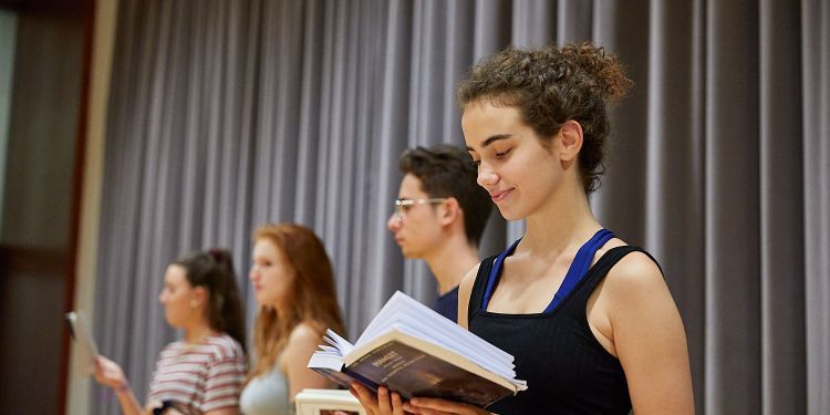 Participant holding text reading in room