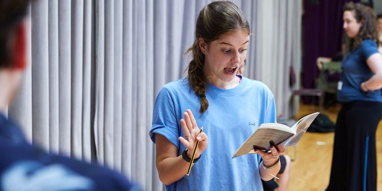 Course participant holding a text and reading aloud from it