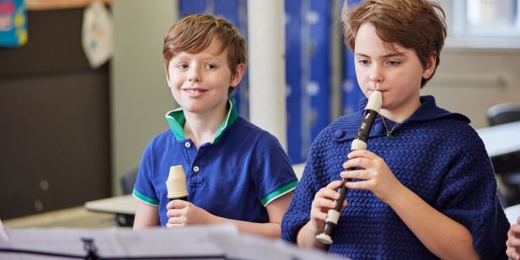 Two boys playing a recorder 