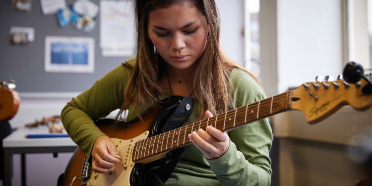 A girl plays a guitar