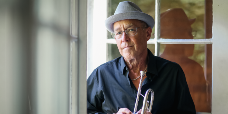 Dave Douglas holding trumpet with window in background