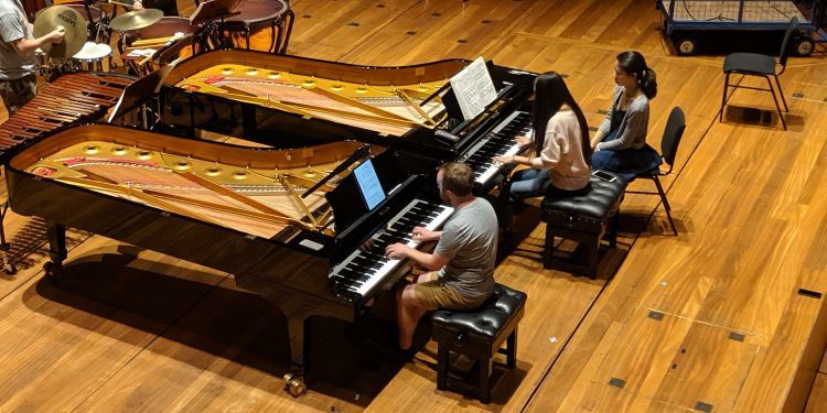 Two pianists on stage performing 