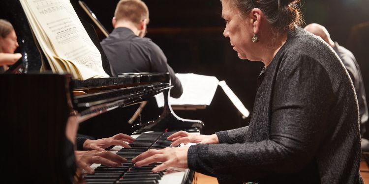 Close up of pianist with string players in background