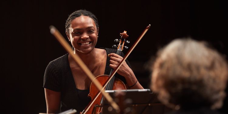 Female student laughing with her violin
