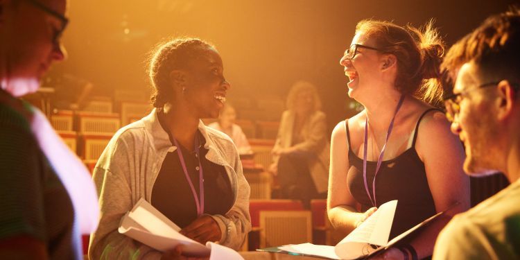 Two stage management participants smile and laugh with each 