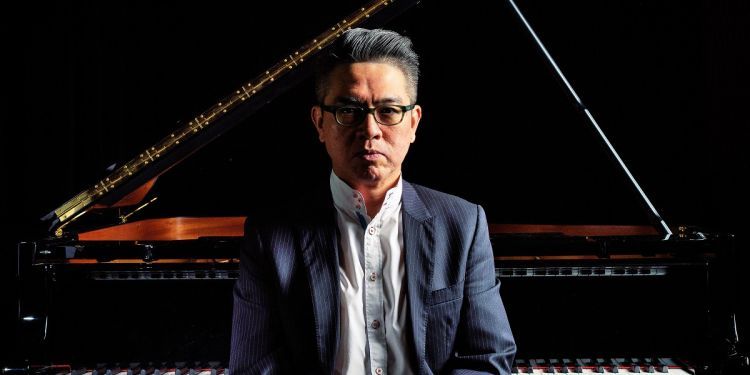 Albert Tiu in front of a piano