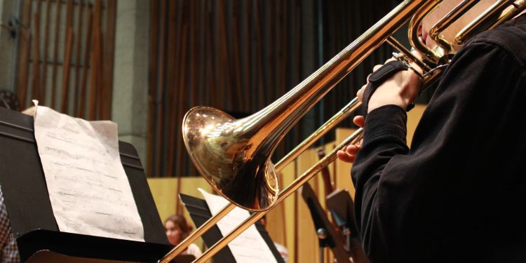 Zoomed in photo of a students hands playing a trumpet