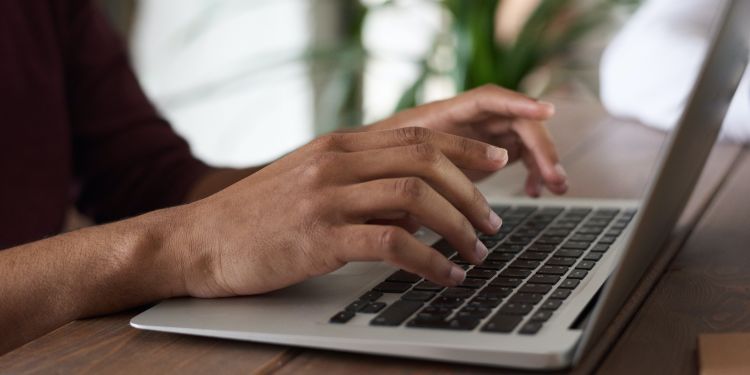 A pair of hands on a mac book 