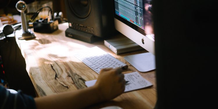 Student working on Logic Pro at their sunlit desk.