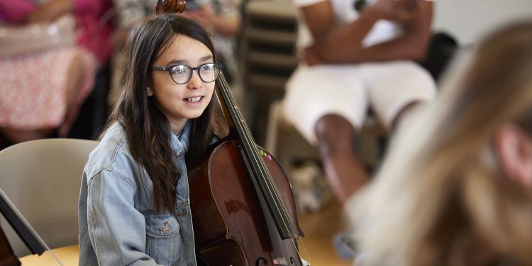 A girl holds a cello 