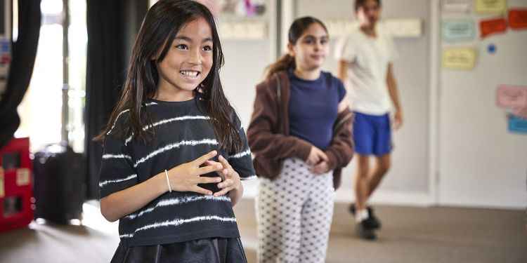 A girl smiles in her drama lesson