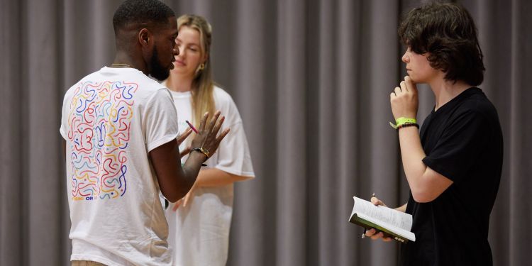 Teacher talks to two participants
